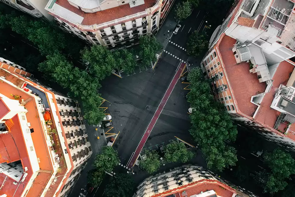 An aerial view over buildings and a street intersection, showcasing a layout of an urban area.