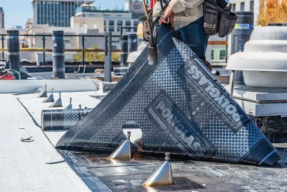 a man laying down new roofing material