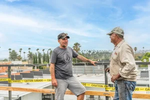 two men standing on a commercial building roof talking