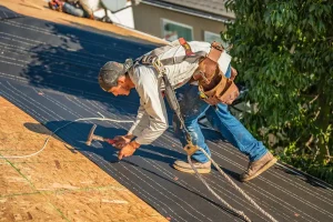 a roofing contractor laying down a layer of roofing material