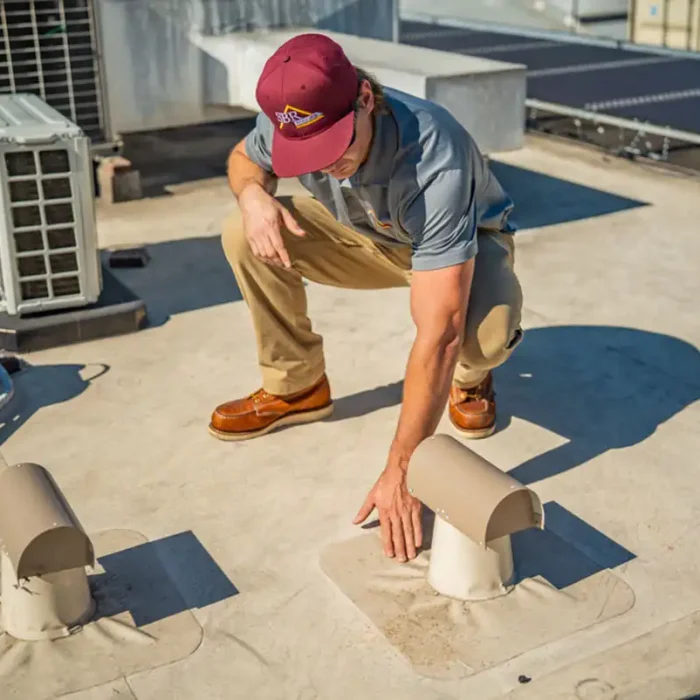 A roofing contractor performing a commercial roof inspection