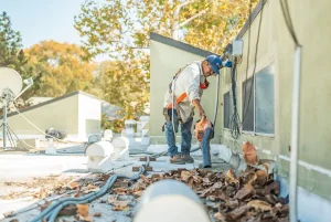 5 Reasons Commercial Roofs Fail in Rainy Season | SBR Roofing a commercial roofing contractor blowing leaves off a commercial roof