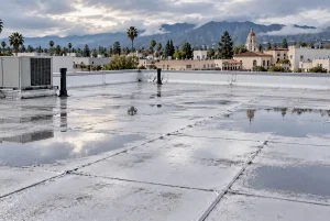 Flat Roof Ponding: What Property Managers Need to Know | SBR Roofing a commercial flat roof with rain puddles after a storm
