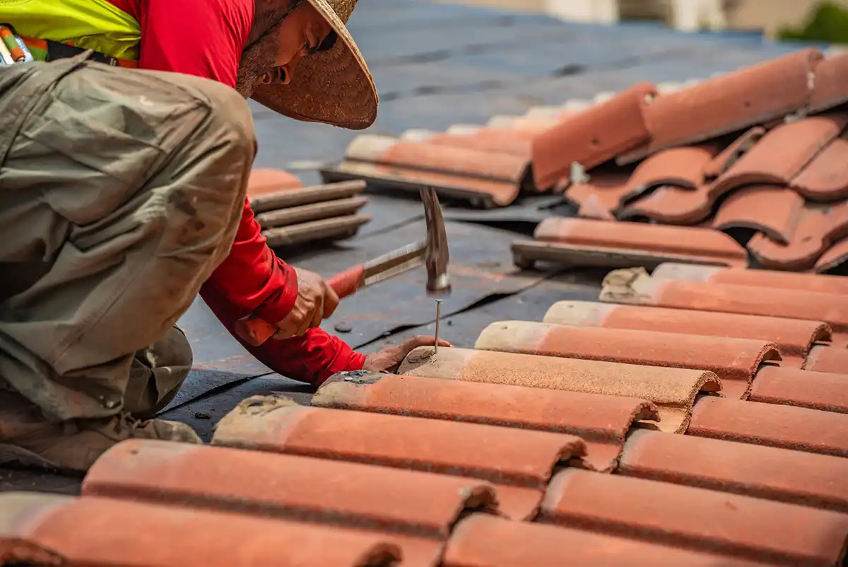 an SBR roofing contractor nailing roofing tiles onto a California roof